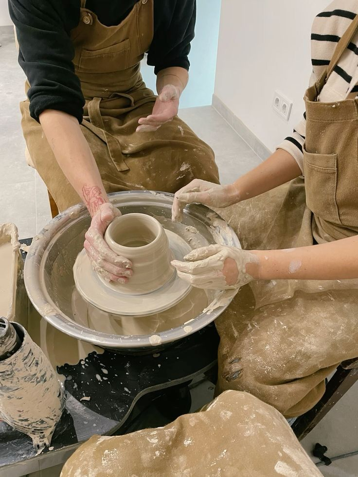 Couples enjoying a pottery workshop together, an experiential one year anniversary gifts for him