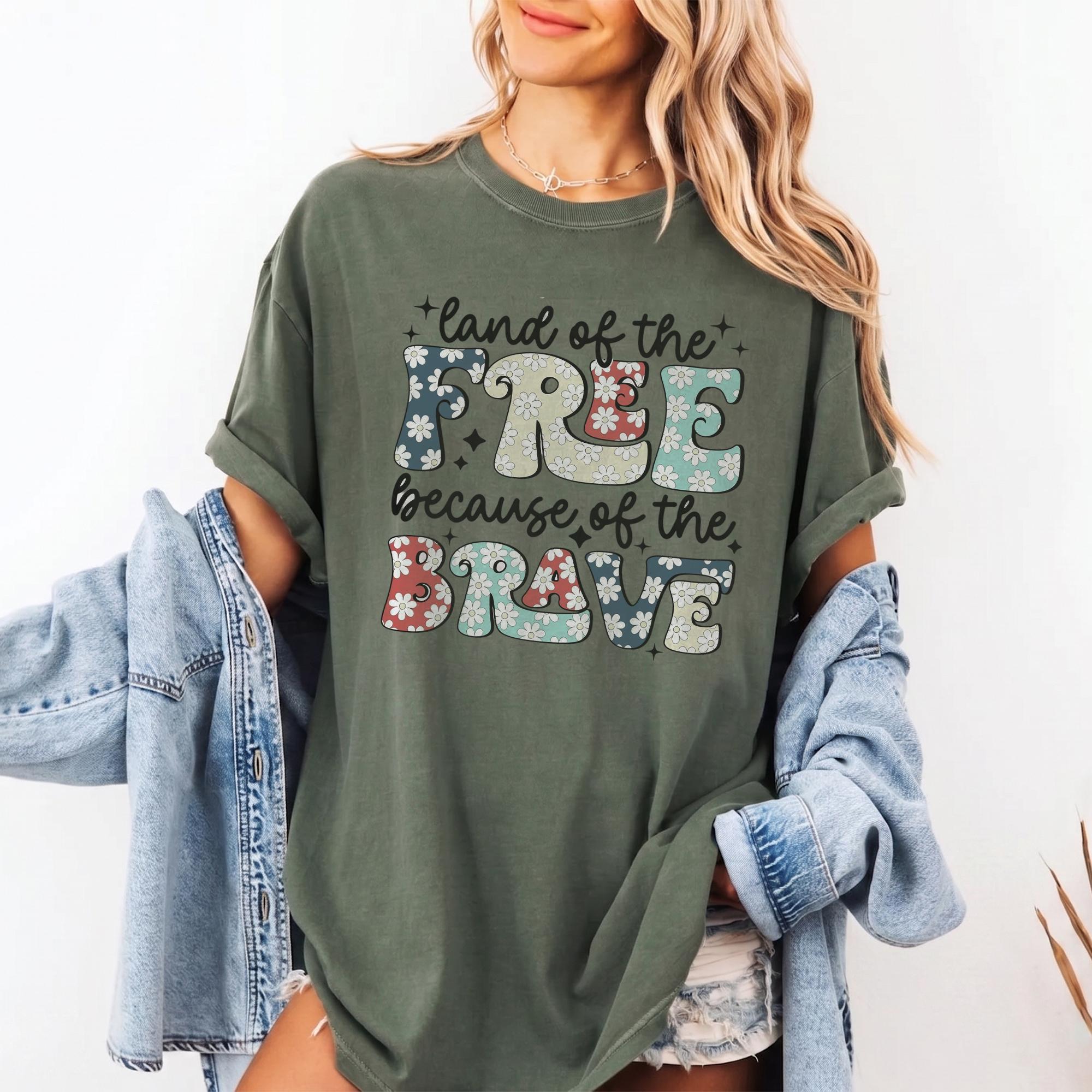 Land Of The Free Because Of The Brave Patriotic Graphic T-Shirt For Women Retro Groovy Floral Western Aesthetic White Cotton Oversized Tee 4th Of July Memorial Day USA Pride Summer Festival Top Outfit Idea 2
