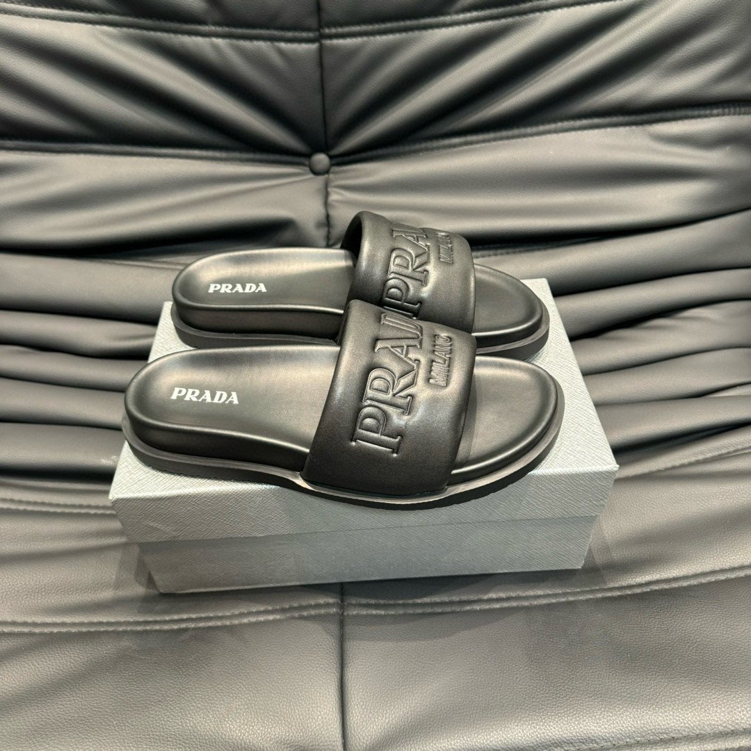 Prada Debossed Logo Padded Nappa Slides In Black