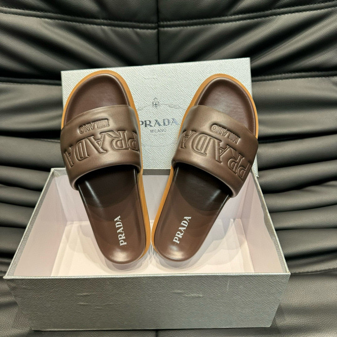 Prada Debossed Logo Padded Nappa Slides In Brown